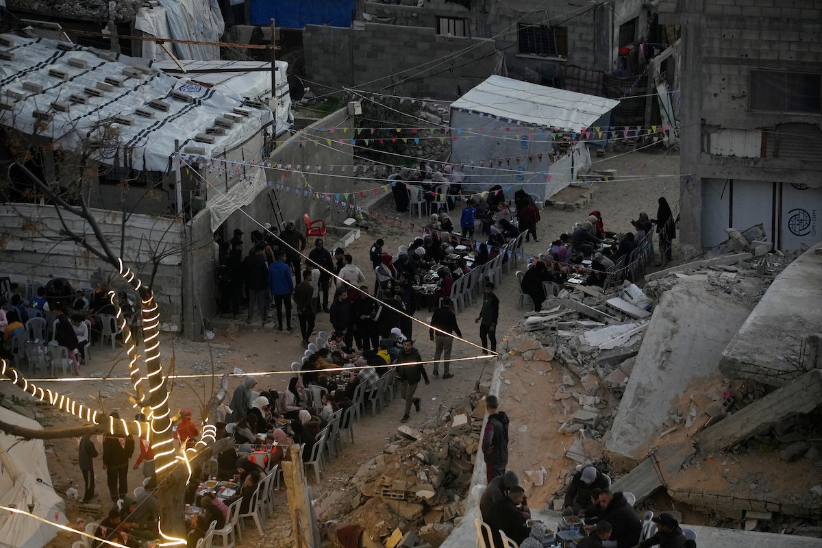 يتجمع الفلسطينيون بين المنازل المدمرة لتناول وجبة الإفطار معًا خلال شهر رمضان المبارك في شمال قطاع غزة، 22 فبراير/شباط 2026. صورة: عمر أشتوي