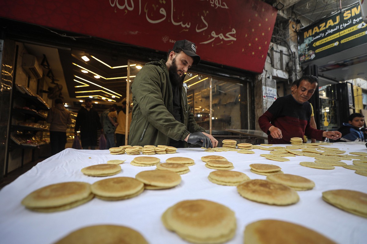 يتسوق الفلسطينيون في أول ليلة من شهر رمضان المبارك في سوق الزاوية، الواقع في قلب مدينة غزة والذي تضرر بشدة جراء الحرب الإسرائيلية. يعرض الباعة بضائعهم على أكشاك مزينة بالفوانيس والأضواء وأطعمة رمضان. مدينة غزة، 17 فبراير/شباط 2026. تصوير: عمر أشتوي