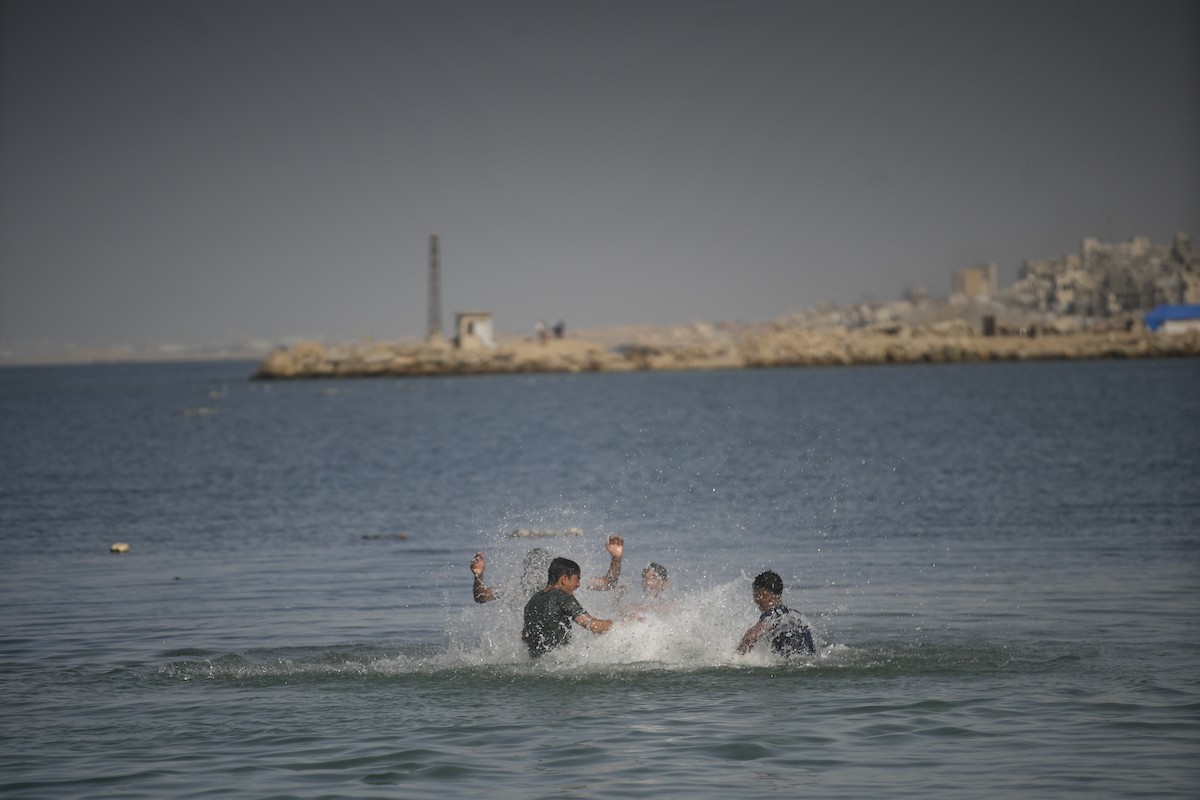 يسبح أطفال قرب ميناء غزة المدمر، في مشهد يعكس تمسكهم بلحظات الفرح رغم الدمار المحيط بهم. يُعدّ البحر في غزة المتنفس الوحيد لسكانها الذين يواجهون آثار الحرب والنزوح، والذين يعيشون في خيام تفتقر لأبسط مقومات الحياة، ١٢ فبراير ٢٠٢٦. تصوير: عمر أشتوي