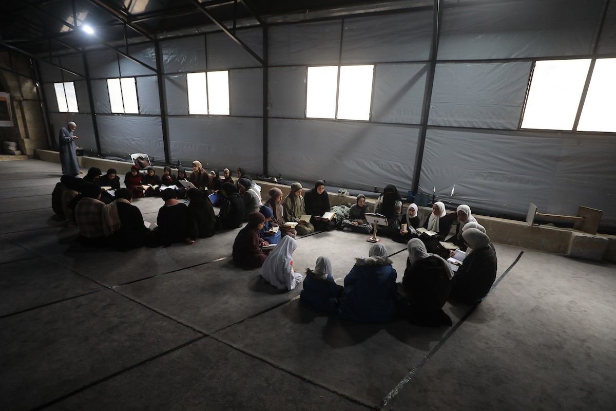 أطفال فلسطينيون يتلون ويحفظون القرآن الكريم داخل الجامع العمري الكبير في مدينة غزة خلال شهر رمضان. وقد تضرر الجامع العمري القديم بشدة جراء الهجمات الإسرائيلية خلال حرب غزة في 26 فبراير/شباط 2026. صورة: عمر أشتوي