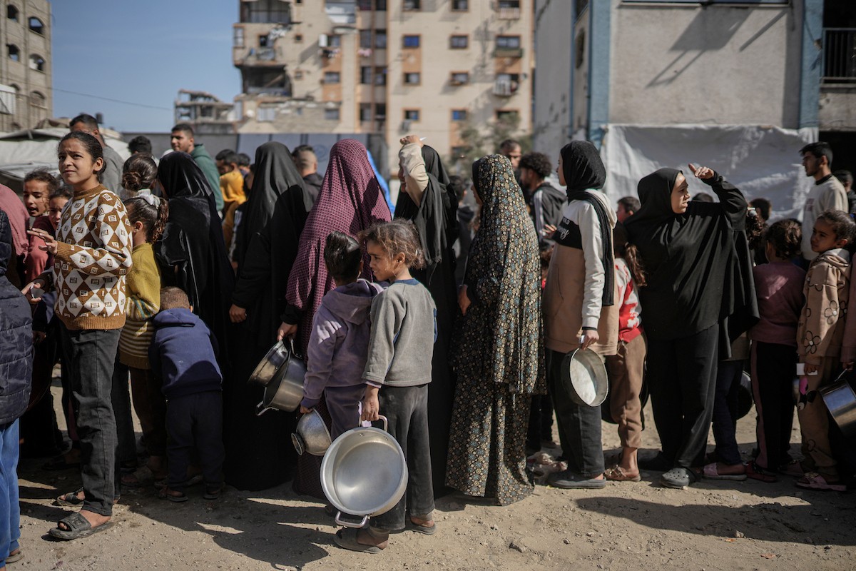 فلسطينيون بينهم أطفال ونساء يتلقون مساعدات غذائية وزعتها منظمات خيرية في أحد مراكز الإيواء بمدينة غزة، وسط أزمة غذائية مستمرة ناجمة عن محدودية المساعدات الإنسانية والظروف الإنسانية المتردية التي يواجهها النازحون، ١٢ فبراير/شباط ٢٠٢٦. تصوير: عمر أشتوي