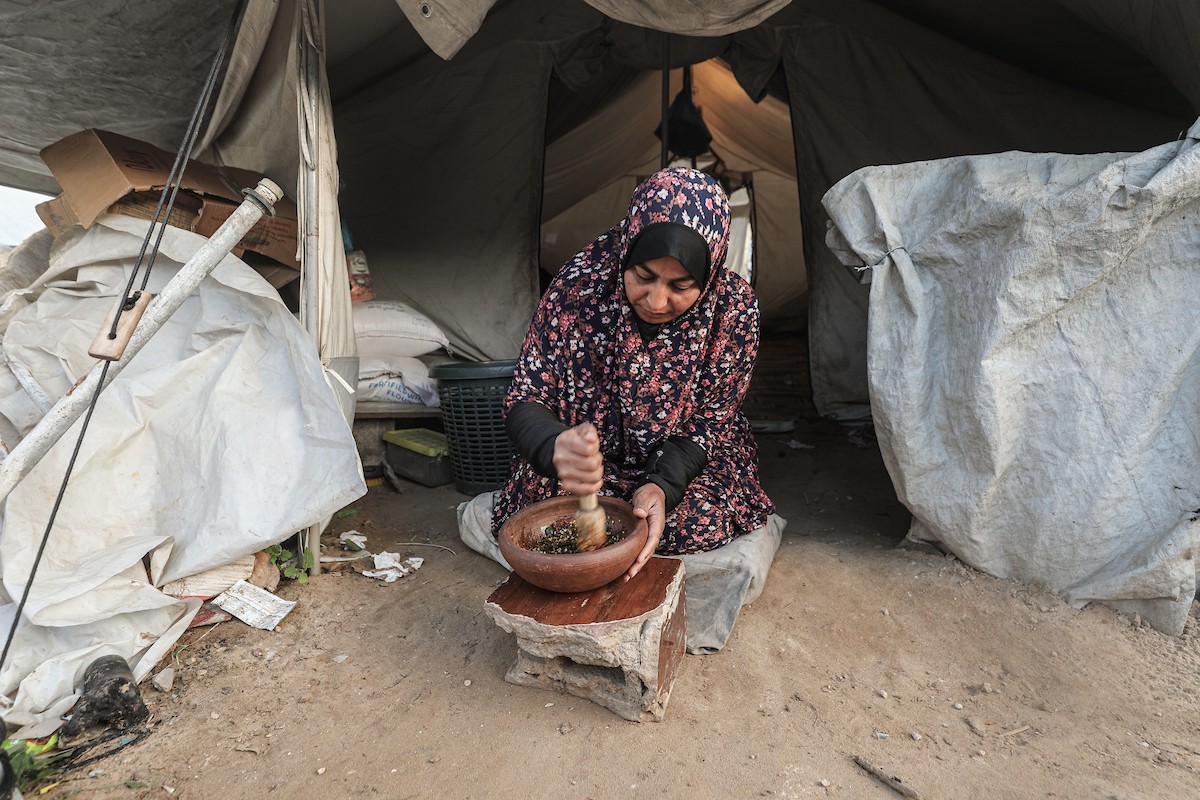 عائلة فلسطينية نازحة تتناول فطورها خلال شهر رمضان داخل خيمة متداعية في مخيم النصيرات للاجئين وسط قطاع غزة. تواجه العائلات النازحة ظروفًا معيشية قاسية نتيجة الحرب، مع انعدام الدخل ونقص حاد في المساعدات الإنسانية، 26 فبراير/شباط 2026. تصوير: معز صالحي