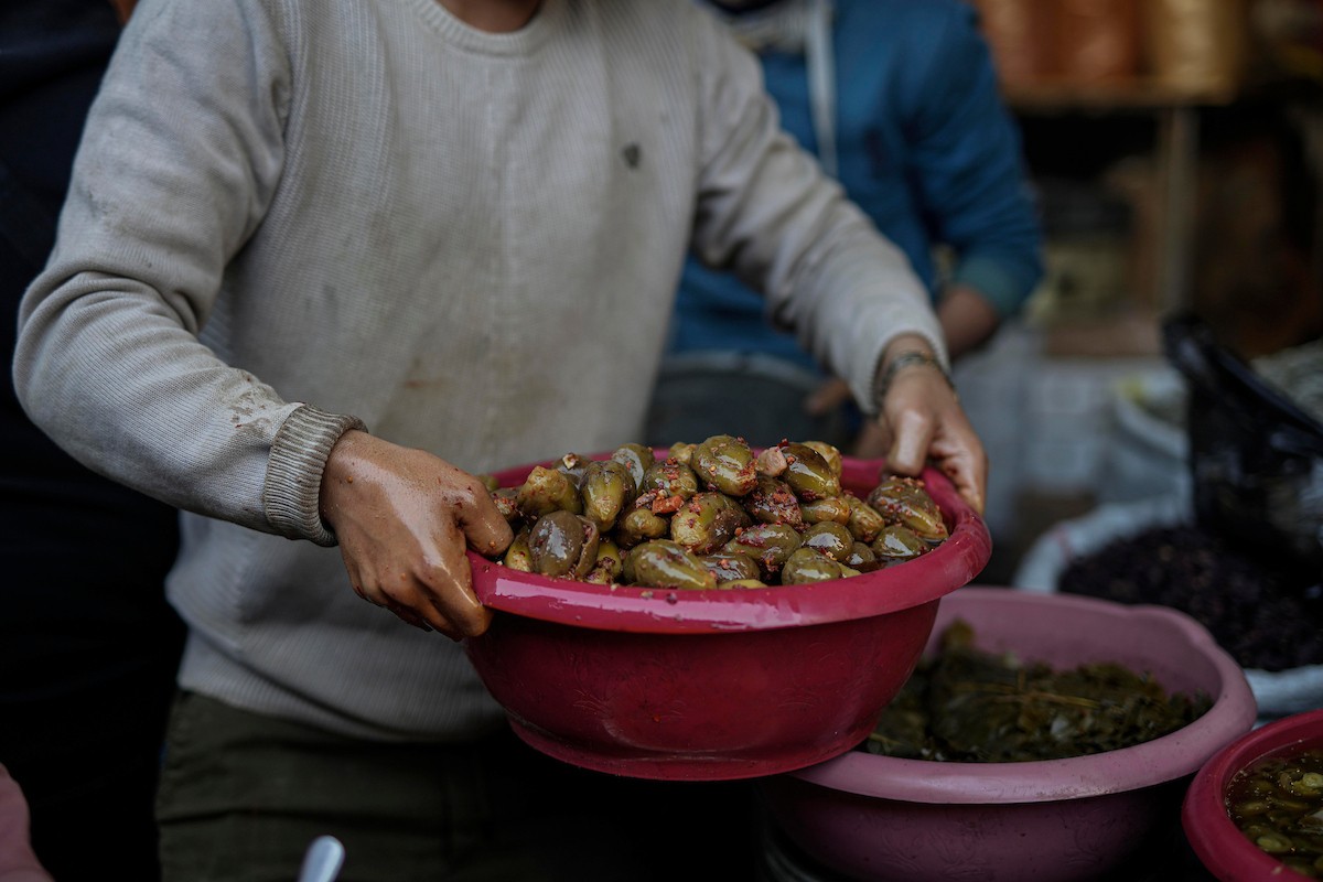 يتسوق الفلسطينيون في أول ليلة من شهر رمضان المبارك في سوق الزاوية، الواقع في قلب مدينة غزة والذي تضرر بشدة جراء الحرب الإسرائيلية. يعرض الباعة بضائعهم على أكشاك مزينة بالفوانيس والأضواء وأطعمة رمضان. مدينة غزة، 17 فبراير/شباط 2026. تصوير: عمر أشتوي
