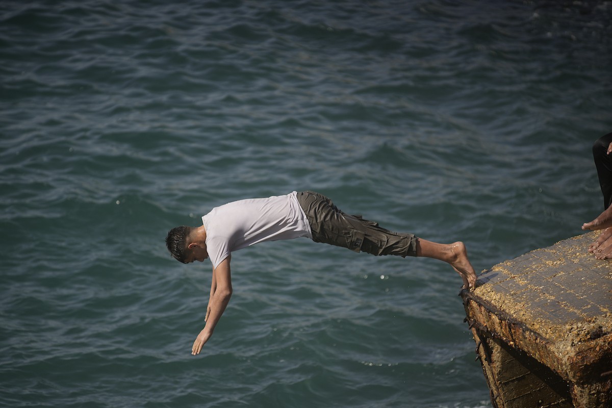 يسبح أطفال قرب ميناء غزة المدمر، في مشهد يعكس تمسكهم بلحظات الفرح رغم الدمار المحيط بهم. يُعدّ البحر في غزة المتنفس الوحيد لسكانها الذين يواجهون آثار الحرب والنزوح، والذين يعيشون في خيام تفتقر لأبسط مقومات الحياة، ١٢ فبراير ٢٠٢٦. تصوير: عمر أشتوي