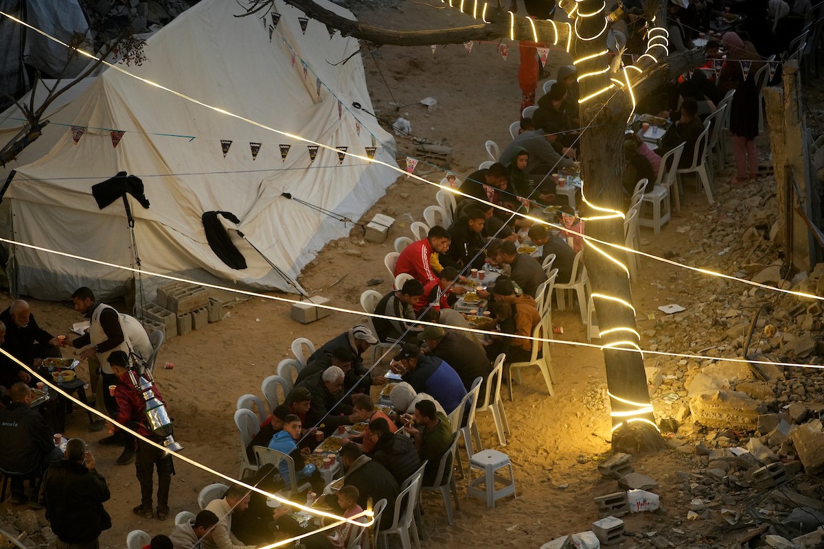 يتجمع الفلسطينيون بين المنازل المدمرة لتناول وجبة الإفطار معًا خلال شهر رمضان المبارك في شمال قطاع غزة، 22 فبراير/شباط 2026. صورة: عمر أشتوي