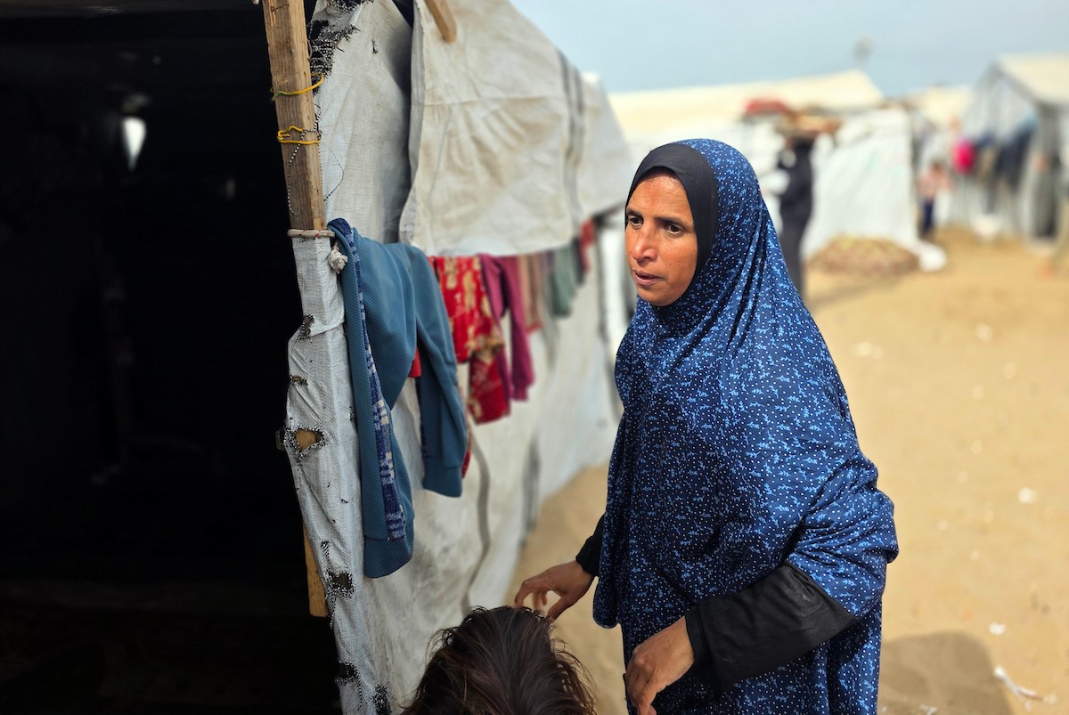 هالة عوض (48 عاما) كفيفة فقدت زوجها في هجوم إسرائيلي، تعيش مع أطفالها السبعة في خيمة مؤقتة غرب خان يونس، وتعيلهم بمفردها رغم إعاقتها البصرية. تصوير: طارق محمد