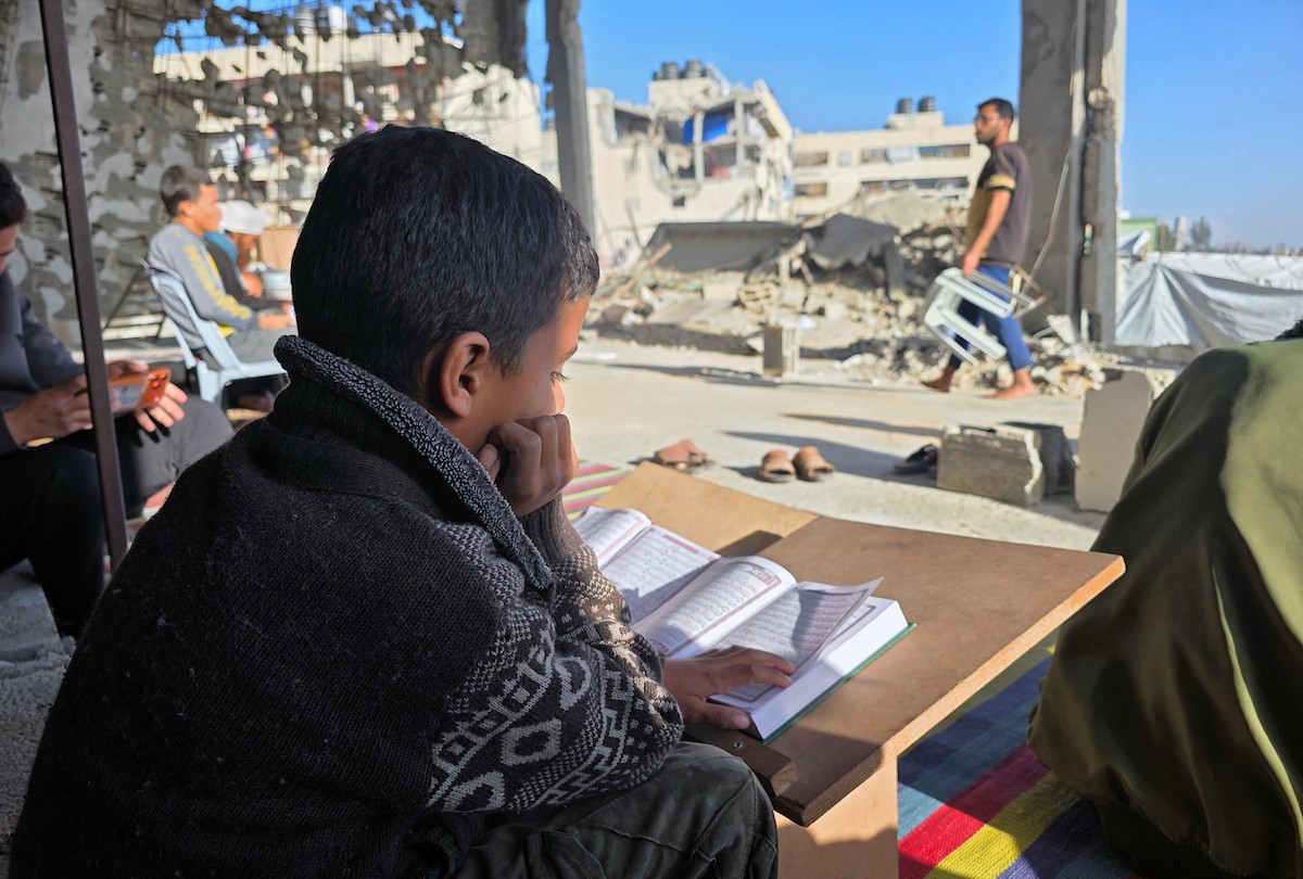 فلسطينيون، بينهم أطفال، يتلون ويحفظون القرآن الكريم خلال شهر رمضان داخل مسجد الألباني، الذي تضرر بشدة جراء الهجمات الإسرائيلية، في خان يونس، جنوب قطاع غزة، في 23 فبراير/شباط 2026. صورة: طارق محمد