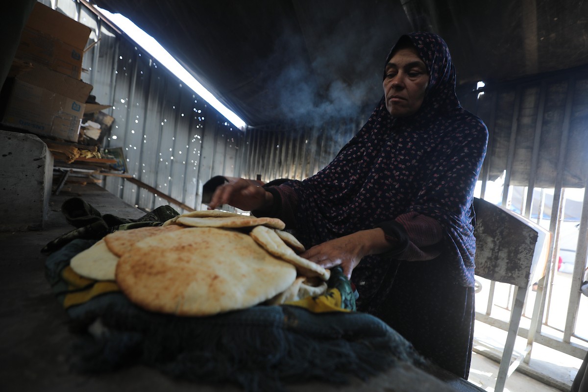 مجموعة من النساء يعملن داخل مخبز أُنشئ في مخيم اليرموك للاجئين بمدينة غزة، ضمن مبادرة إنسانية بالشراكة مع اللجنة الدولية للصليب الأحمر. تهدف المبادرة إلى تخفيف الأعباء المعيشية عن النساء النازحات، لا سيما خلال شهر رمضان. مدينة غزة، 25 فبراير/شباط 2026. تصوير: عمر أشتوي