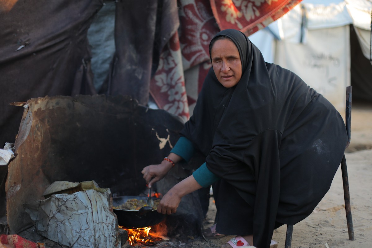 عائلة فلسطينية كفيفة تتناول وجبة الإفطار خارج خيمتها في مخيم بوسط قطاع غزة خلال شهر رمضان