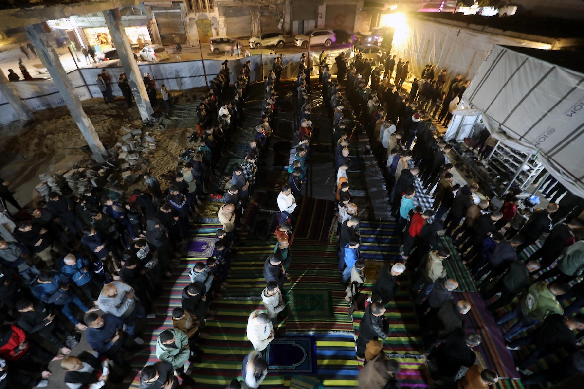 فلسطينيون يؤدون صلاة التراويح في أول ليلة من شهر رمضان على أنقاض مسجد الكنز المدمر في مدينة غزة، في 17 فبراير/شباط 2026. وكان مفتي القدس والأراضي الفلسطينية قد أعلن أن يوم الأربعاء 18 فبراير/شباط 2026 هو أول أيام رمضان. (صورة: عمر أشتوي)