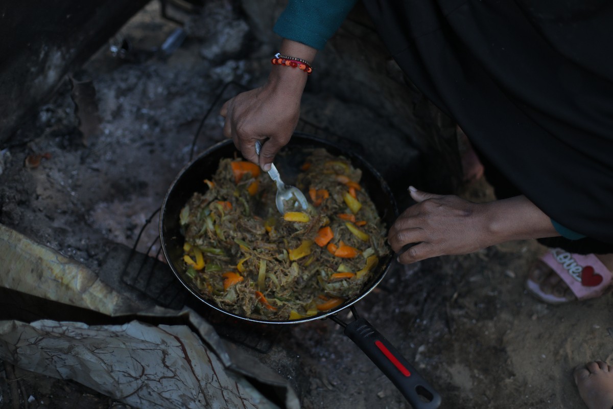 عائلة فلسطينية كفيفة تتناول وجبة الإفطار خارج خيمتها في مخيم بوسط قطاع غزة خلال شهر رمضان