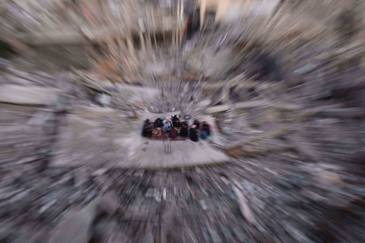 عائلة فلسطينية تتناول إفطارها خلال شهر رمضان على سطح منزلها الذي دمره قصف جوي إسرائيلي خلال حرب غزة في 27 فبراير/شباط 2026. صورة: عمر أشتوي