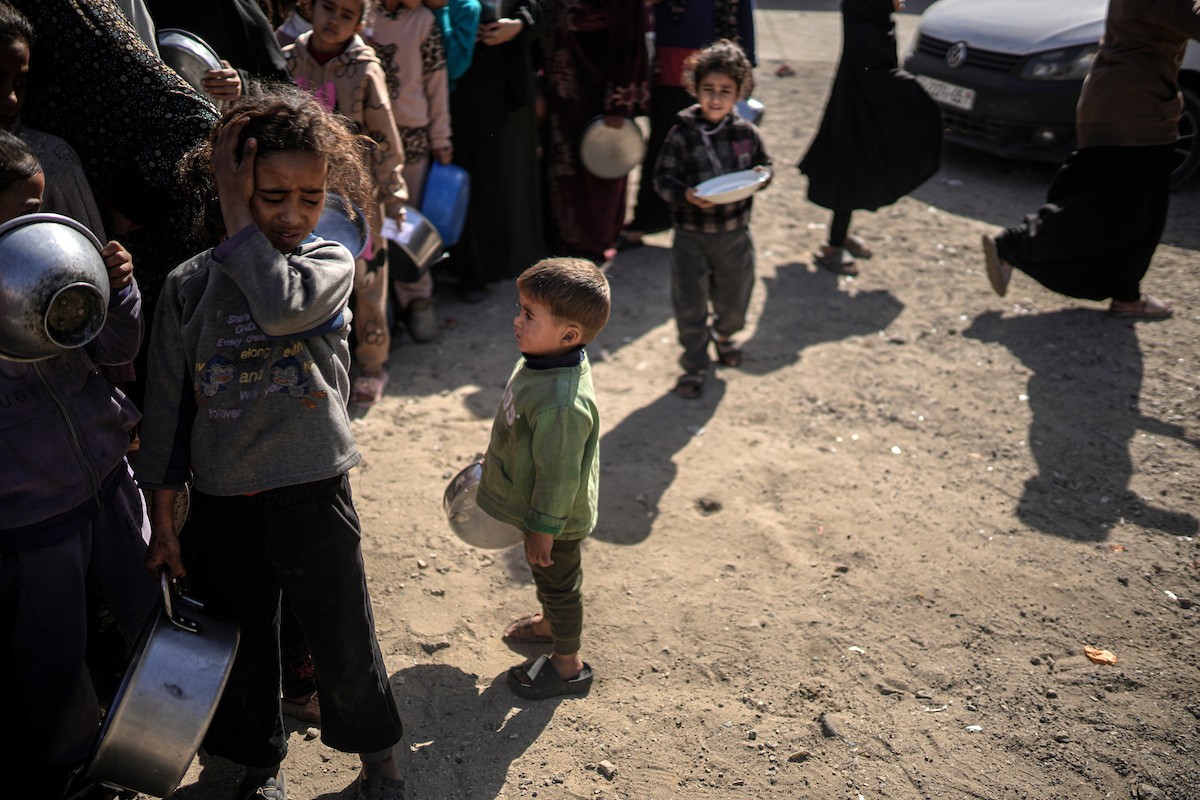 فلسطينيون بينهم أطفال ونساء يتلقون مساعدات غذائية وزعتها منظمات خيرية في أحد مراكز الإيواء بمدينة غزة، وسط أزمة غذائية مستمرة ناجمة عن محدودية المساعدات الإنسانية والظروف الإنسانية المتردية التي يواجهها النازحون، ١٢ فبراير/شباط ٢٠٢٦. تصوير: عمر أشتوي