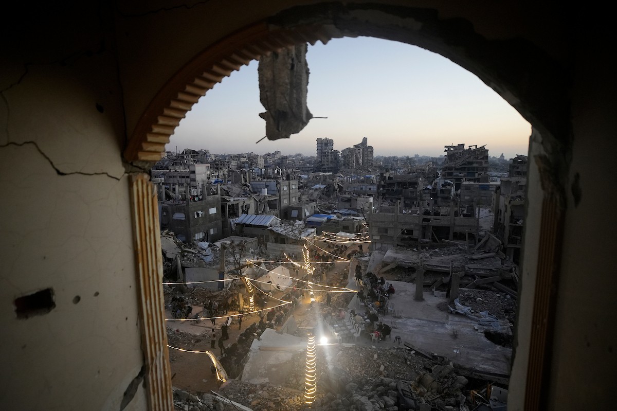 يتجمع الفلسطينيون بين المنازل المدمرة لتناول وجبة الإفطار معًا خلال شهر رمضان المبارك في شمال قطاع غزة، 22 فبراير/شباط 2026. صورة: عمر أشتوي