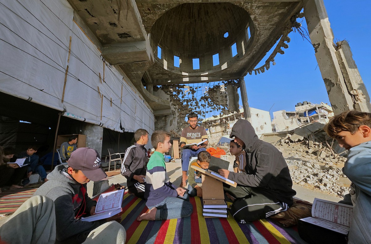 فلسطينيون، بينهم أطفال، يتلون ويحفظون القرآن الكريم خلال شهر رمضان داخل مسجد الألباني، الذي تضرر بشدة جراء الهجمات الإسرائيلية، في خان يونس، جنوب قطاع غزة، في 23 فبراير/شباط 2026. صورة: طارق محمد