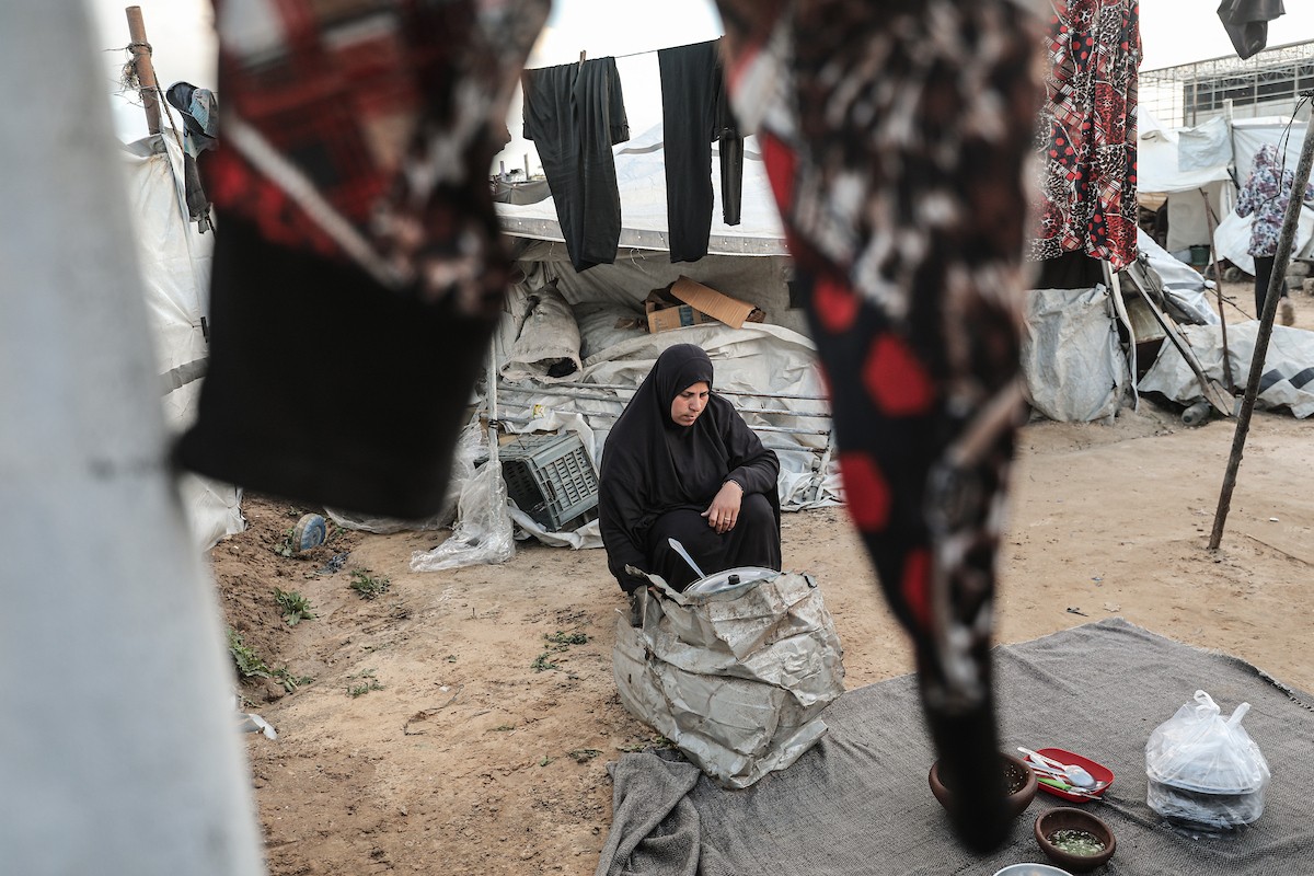 عائلة فلسطينية نازحة تتناول فطورها خلال شهر رمضان داخل خيمة متداعية في مخيم النصيرات للاجئين وسط قطاع غزة. تواجه العائلات النازحة ظروفًا معيشية قاسية نتيجة الحرب، مع انعدام الدخل ونقص حاد في المساعدات الإنسانية، 26 فبراير/شباط 2026. تصوير: معز صالحي