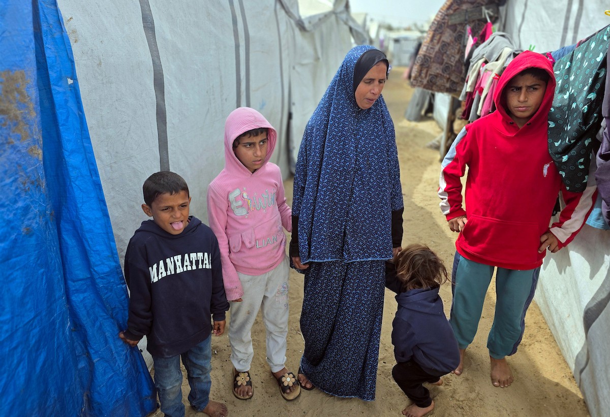 هالة عوض (48 عاما) كفيفة فقدت زوجها في هجوم إسرائيلي، تعيش مع أطفالها السبعة في خيمة مؤقتة غرب خان يونس، وتعيلهم بمفردها رغم إعاقتها البصرية. تصوير: طارق محمد