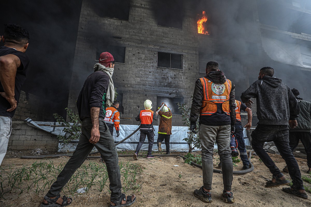طواقم الدفاع المدني ومتطوعون من المواطنين أثناء محاولة إخماد حريق اندلع في مستودع تابع لمنظمة إغاثة في حي الرمال، غرب مدينة غزة، في 13 فبراير/شباط 2026. صورة: عمر أشتوي