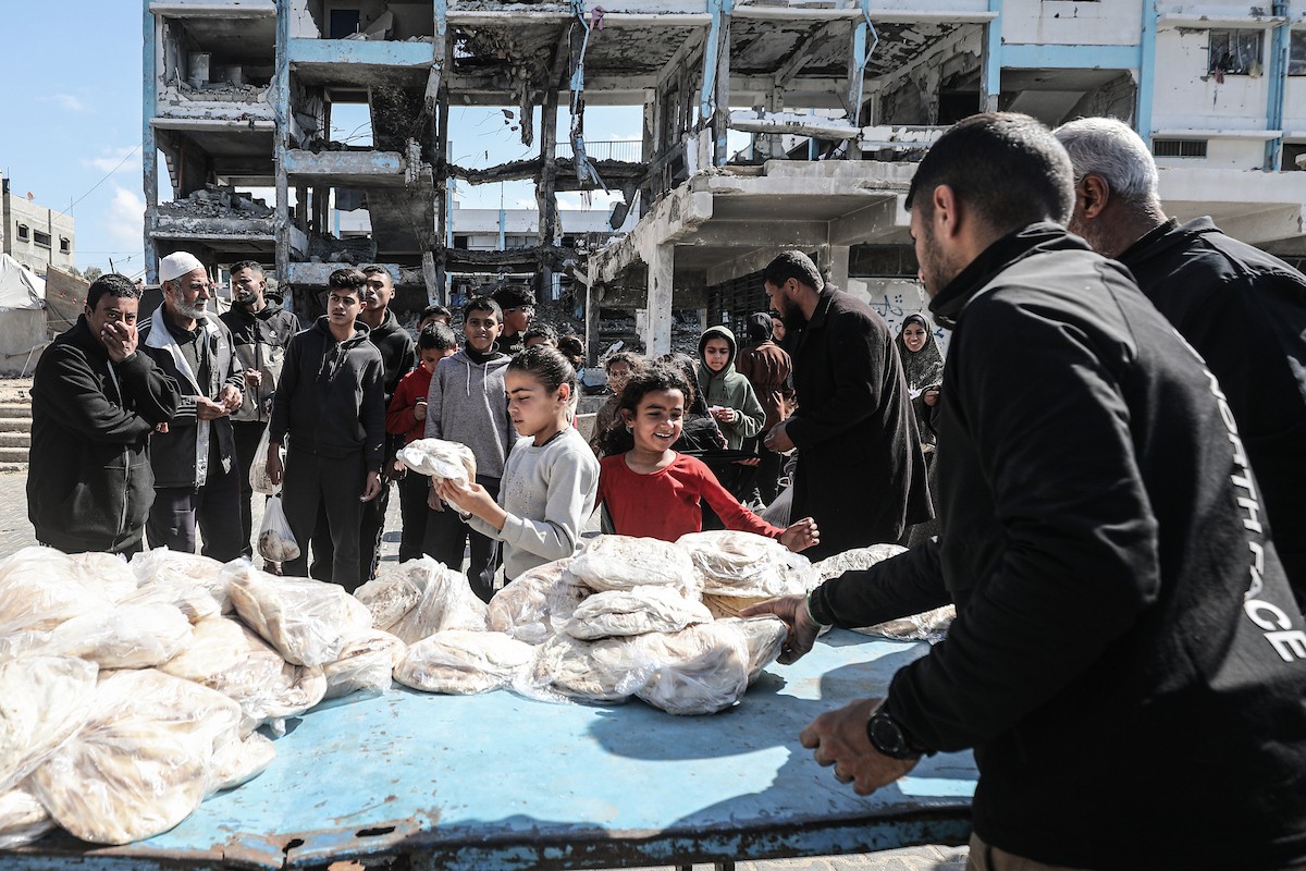 نساء فلسطينيات، زوجات شهداء الحرب، يُجهّزن الخبز لتوزيعه على العائلات النازحة والمحتاجة في مخيم البريج للاجئين وسط قطاع غزة خلال شهر رمضان، في مشهد يُجسّد روح التضامن والصمود في ظلّ الظروف الإنسانية الصعبة، فبراير/شباط 2026. تصوير: معز صالحي