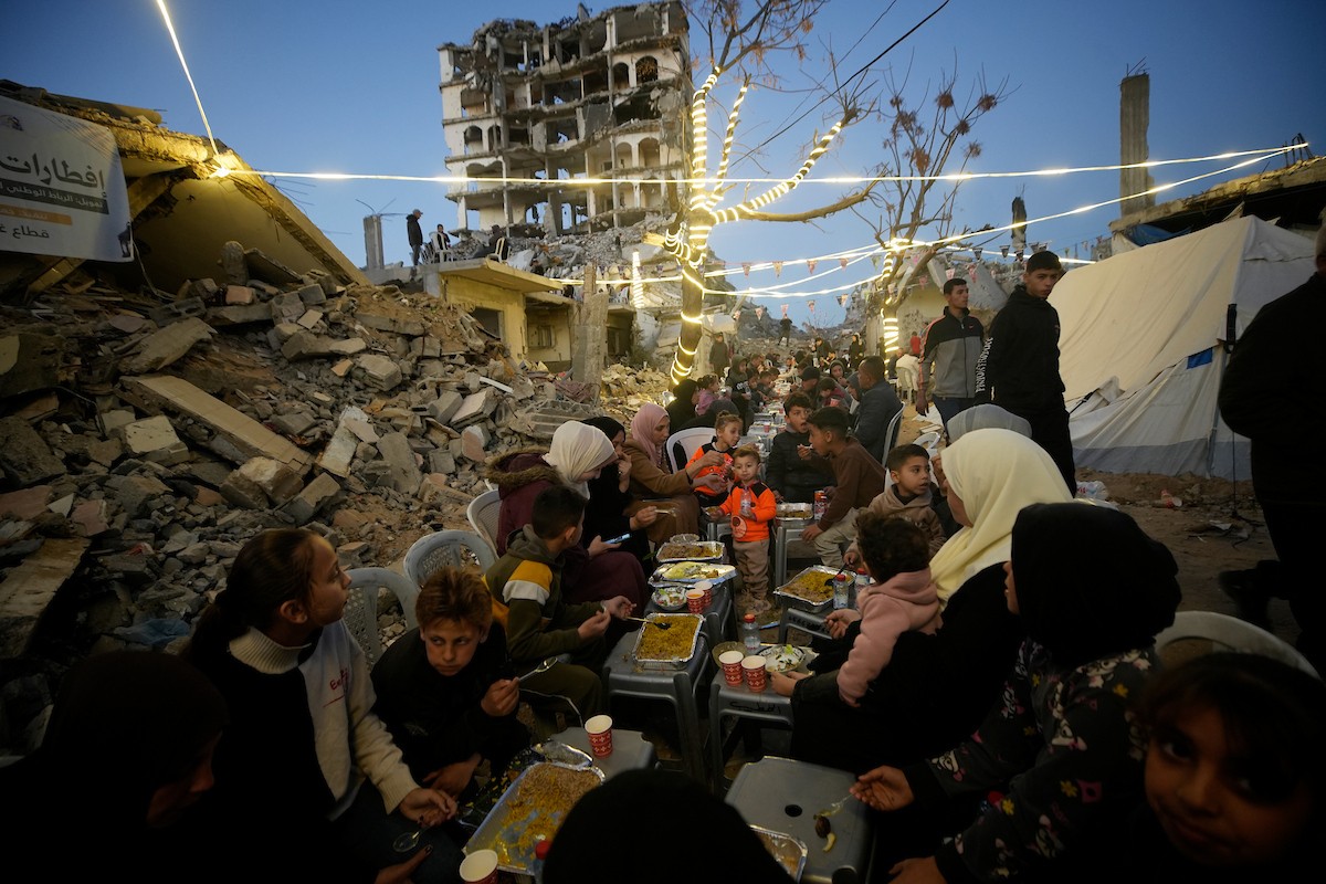 يتجمع الفلسطينيون بين المنازل المدمرة لتناول وجبة الإفطار معًا خلال شهر رمضان المبارك في شمال قطاع غزة، 22 فبراير/شباط 2026. صورة: عمر أشتوي