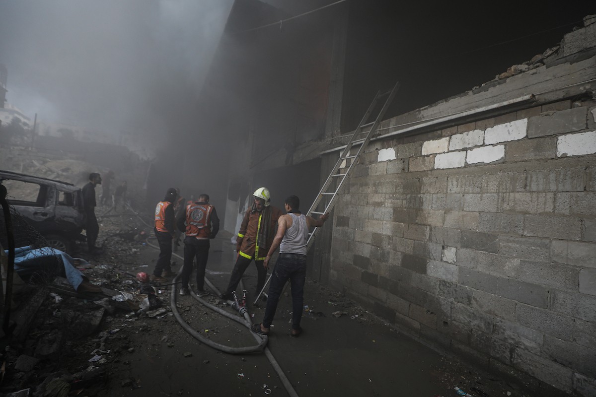 طواقم الدفاع المدني ومتطوعون من المواطنين أثناء محاولة إخماد حريق اندلع في مستودع تابع لمنظمة إغاثة في حي الرمال، غرب مدينة غزة، في 13 فبراير/شباط 2026. صورة: عمر أشتوي