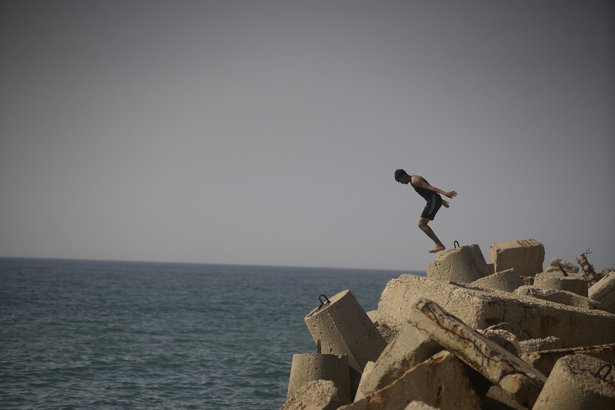 يسبح أطفال قرب ميناء غزة المدمر، في مشهد يعكس تمسكهم بلحظات الفرح رغم الدمار المحيط بهم. يُعدّ البحر في غزة المتنفس الوحيد لسكانها الذين يواجهون آثار الحرب والنزوح، والذين يعيشون في خيام تفتقر لأبسط مقومات الحياة، ١٢ فبراير ٢٠٢٦. تصوير: عمر أشتوي