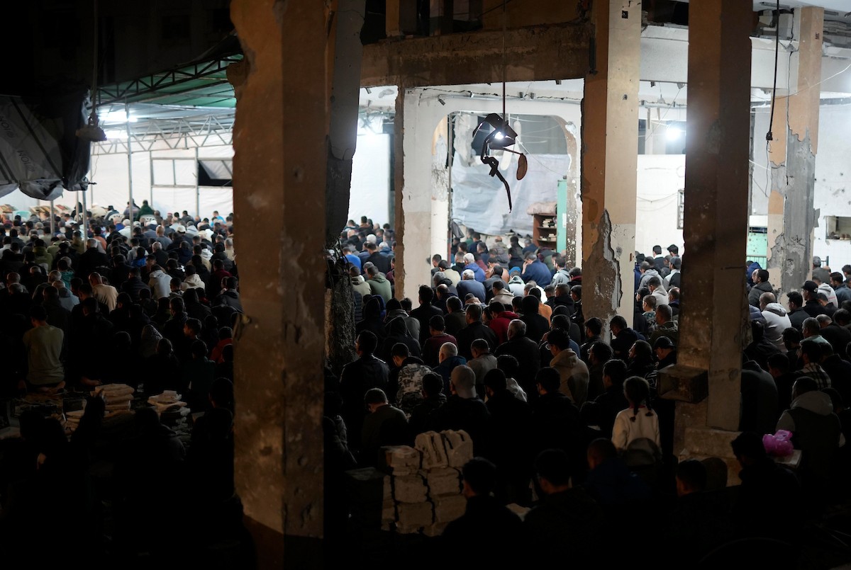 فلسطينيون يؤدون صلاة التراويح في أول ليلة من شهر رمضان على أنقاض مسجد الكنز المدمر في مدينة غزة، في 17 فبراير/شباط 2026. وكان مفتي القدس والأراضي الفلسطينية قد أعلن أن يوم الأربعاء 18 فبراير/شباط 2026 هو أول أيام رمضان. (صورة: عمر أشتوي)