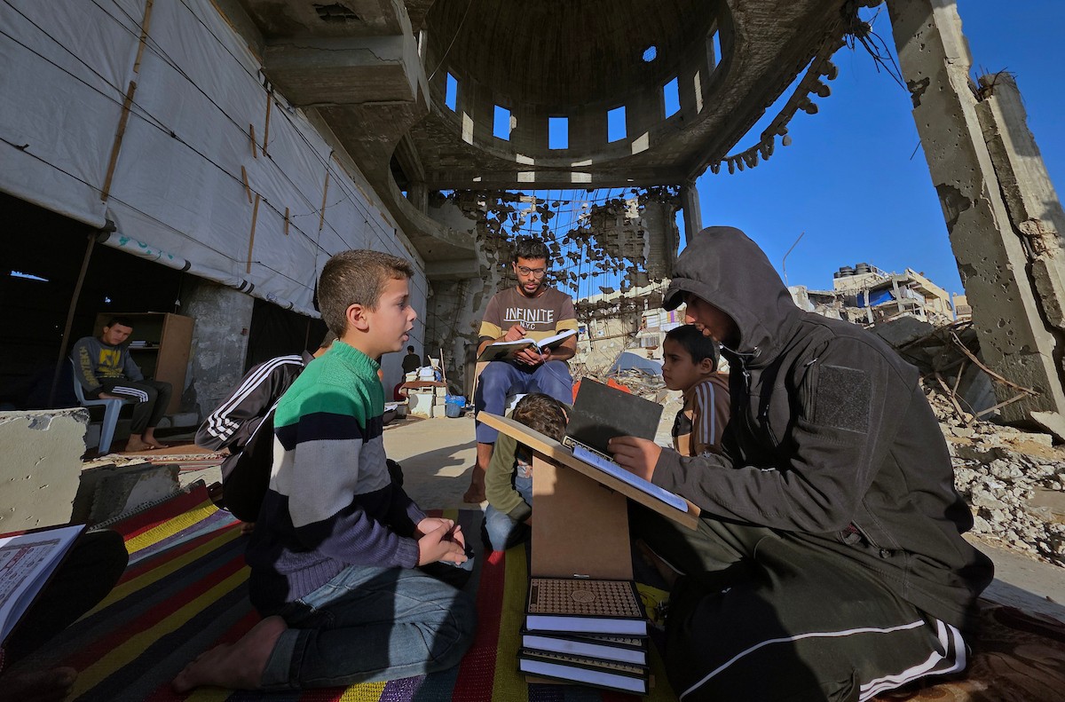 فلسطينيون، بينهم أطفال، يتلون ويحفظون القرآن الكريم خلال شهر رمضان داخل مسجد الألباني، الذي تضرر بشدة جراء الهجمات الإسرائيلية، في خان يونس، جنوب قطاع غزة، في 23 فبراير/شباط 2026. صورة: طارق محمد