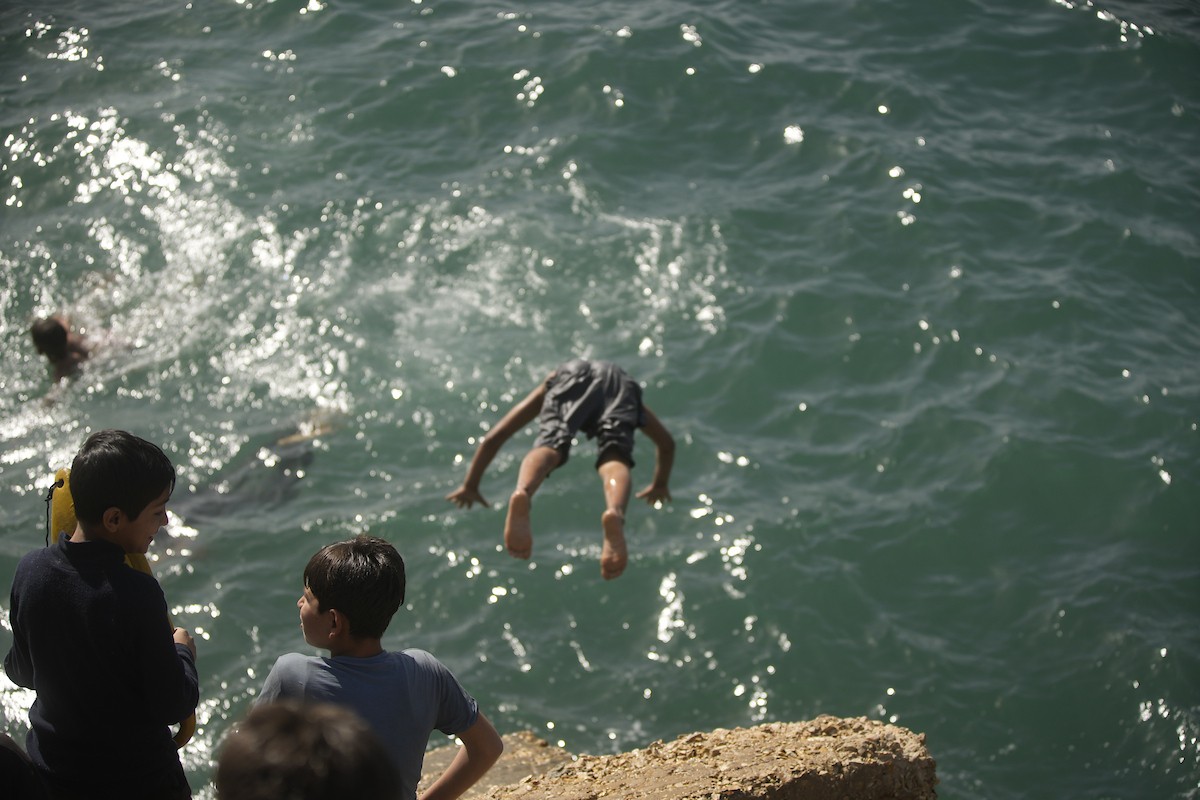 يسبح أطفال قرب ميناء غزة المدمر، في مشهد يعكس تمسكهم بلحظات الفرح رغم الدمار المحيط بهم. يُعدّ البحر في غزة المتنفس الوحيد لسكانها الذين يواجهون آثار الحرب والنزوح، والذين يعيشون في خيام تفتقر لأبسط مقومات الحياة، ١٢ فبراير ٢٠٢٦. تصوير: عمر أشتوي
