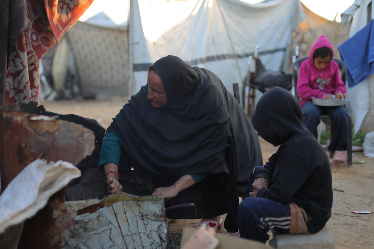 عائلة فلسطينية كفيفة تتناول وجبة الإفطار خارج خيمتها في مخيم بوسط قطاع غزة خلال شهر رمضان