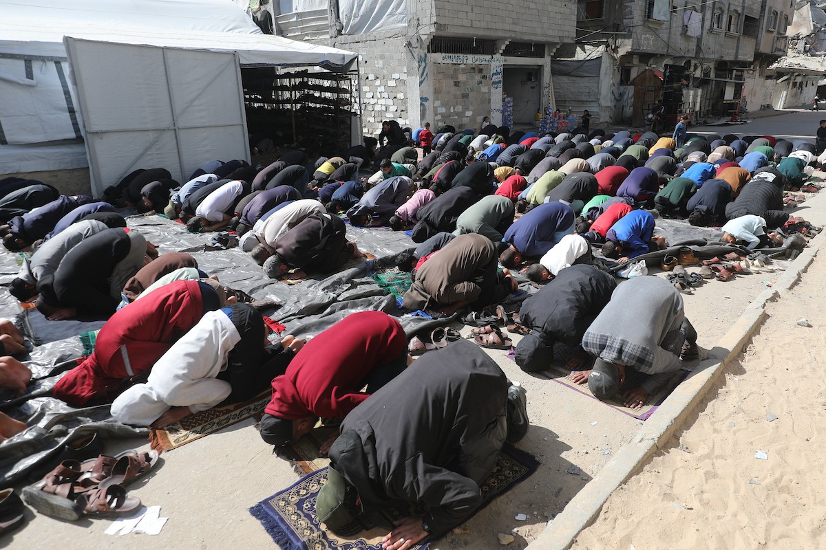يؤدي النازحون أول صلاة جمعة في رمضان بجوار أنقاض مسجد الصفا المدمر بالكامل في مخيم البريج للاجئين وسط قطاع غزة. 20 فبراير/شباط 2026. تصوير: معز صالحي