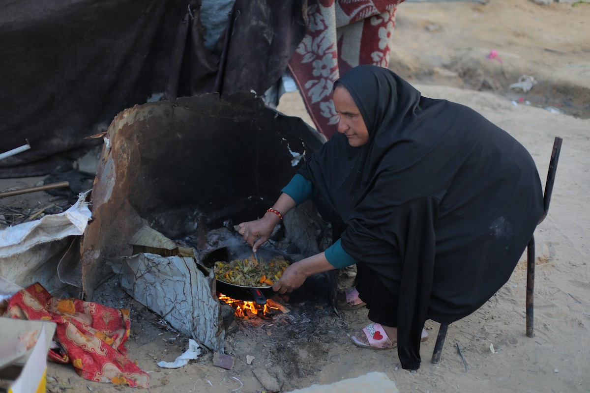 عائلة فلسطينية كفيفة تتناول وجبة الإفطار خارج خيمتها في مخيم بوسط قطاع غزة خلال شهر رمضان