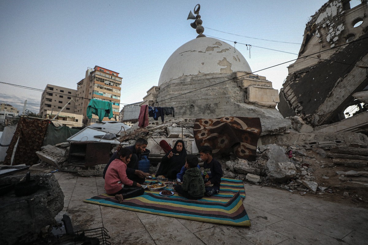 عائلة فلسطينية نازحة من بيت حانون تفطر في ثاني أيام رمضان في خيمة متداعية وسط أنقاض مسجد الحساينة على شاطئ مدينة غزة.19 فبراير/شباط 2026. تصوير: عمر أشتوي