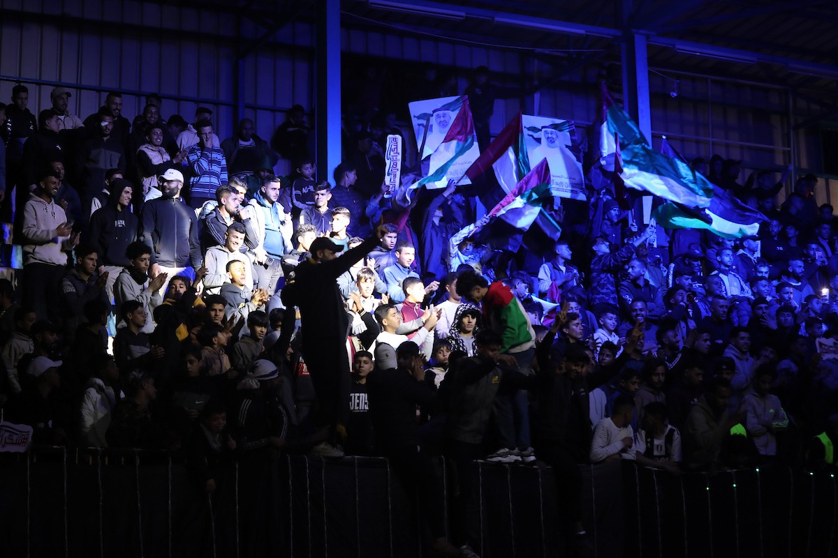 لاعبون فلسطينيون من فريقي النصيرات ورفح يتنافسون خلال مباراة كرة قدم على ملعب نادي خدمات النصيرات، ضمن بطولة غزة الرمضانية، بحضور حشد جماهيري كبير، في مخيم النصيرات بوسط قطاع غزة، بتاريخ 21 فبراير/شباط 2026. تصوير: معز صالحي / apaimages