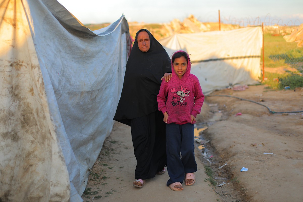 عائلة فلسطينية كفيفة تتناول وجبة الإفطار خارج خيمتها في مخيم بوسط قطاع غزة خلال شهر رمضان