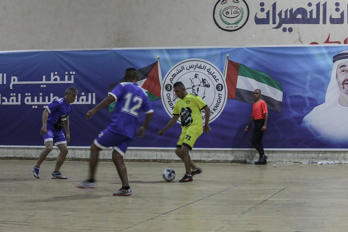 لاعبون فلسطينيون من فريقي النصيرات ورفح يتنافسون خلال مباراة كرة قدم على ملعب نادي خدمات النصيرات، ضمن بطولة غزة الرمضانية، بحضور حشد جماهيري كبير، في مخيم النصيرات بوسط قطاع غزة، بتاريخ 21 فبراير/شباط 2026. تصوير: معز صالحي / apaimages