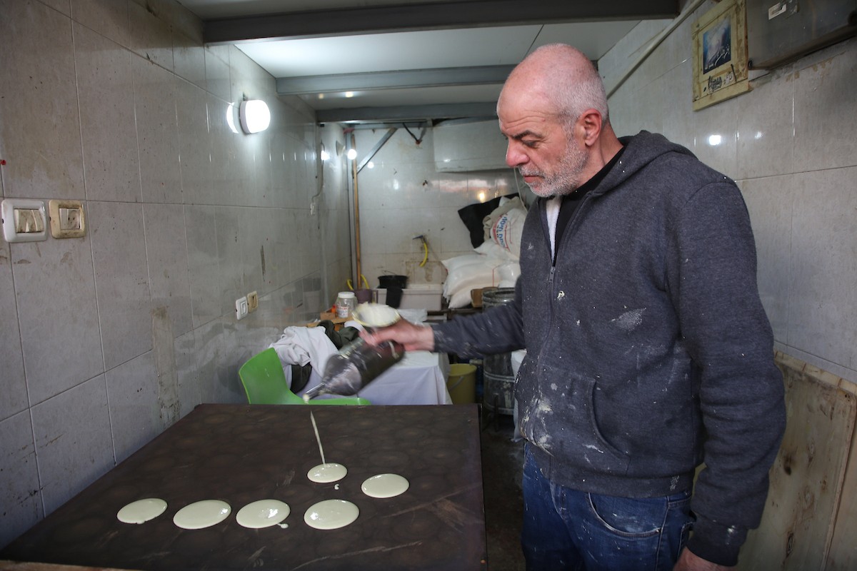 فلسطينيون يتسوقون استعدادًا للإفطار في أول أيام شهر رمضان المبارك، في مدينة نابلس بالضفة الغربية، 18 فبراير/شباط 2026. صورة: محمد ناصر