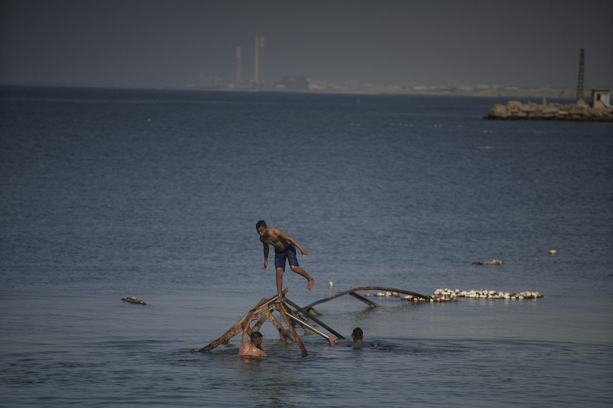 يسبح أطفال قرب ميناء غزة المدمر، في مشهد يعكس تمسكهم بلحظات الفرح رغم الدمار المحيط بهم. يُعدّ البحر في غزة المتنفس الوحيد لسكانها الذين يواجهون آثار الحرب والنزوح، والذين يعيشون في خيام تفتقر لأبسط مقومات الحياة، ١٢ فبراير ٢٠٢٦. تصوير: عمر أشتوي
