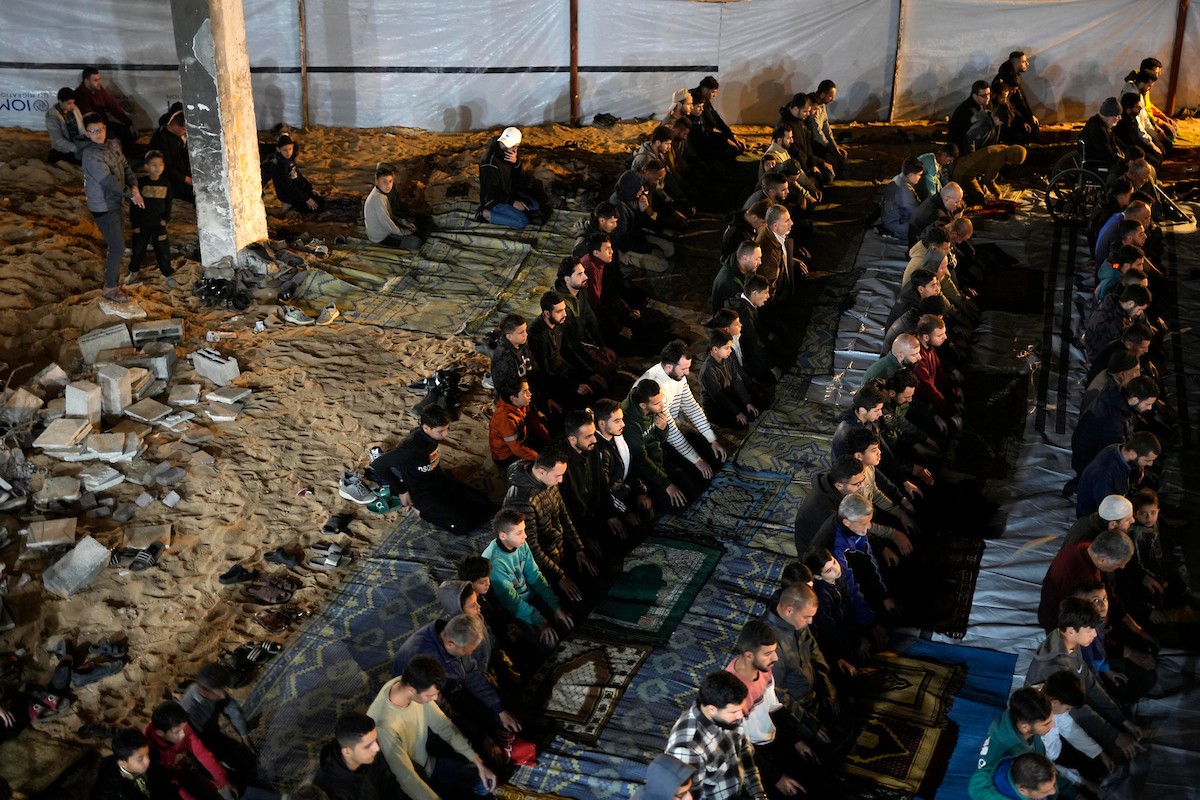 فلسطينيون يؤدون صلاة التراويح في أول ليلة من شهر رمضان على أنقاض مسجد الكنز المدمر في مدينة غزة، في 17 فبراير/شباط 2026. وكان مفتي القدس والأراضي الفلسطينية قد أعلن أن يوم الأربعاء 18 فبراير/شباط 2026 هو أول أيام رمضان. (صورة: عمر أشتوي)