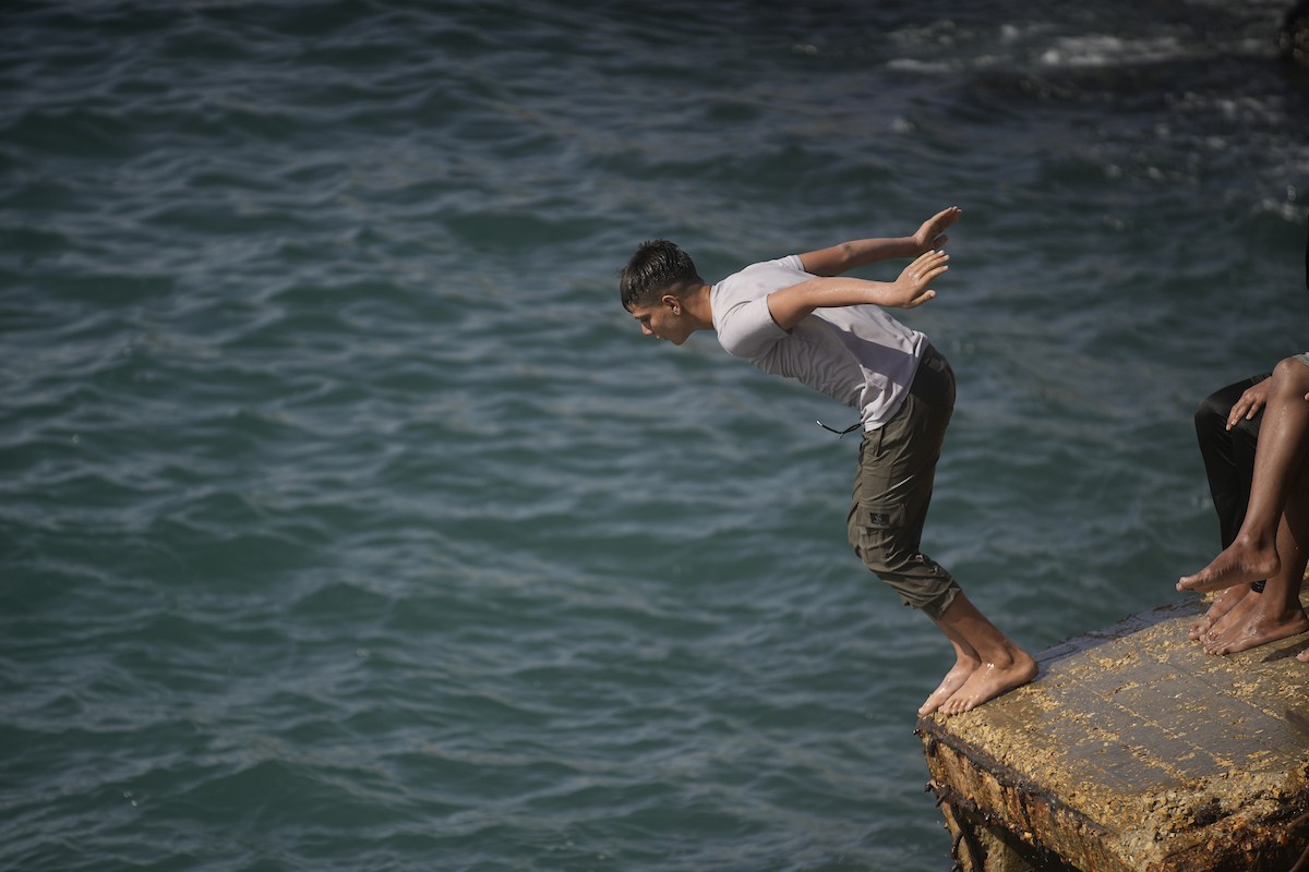 يسبح أطفال قرب ميناء غزة المدمر، في مشهد يعكس تمسكهم بلحظات الفرح رغم الدمار المحيط بهم. يُعدّ البحر في غزة المتنفس الوحيد لسكانها الذين يواجهون آثار الحرب والنزوح، والذين يعيشون في خيام تفتقر لأبسط مقومات الحياة، ١٢ فبراير ٢٠٢٦. تصوير: عمر أشتوي