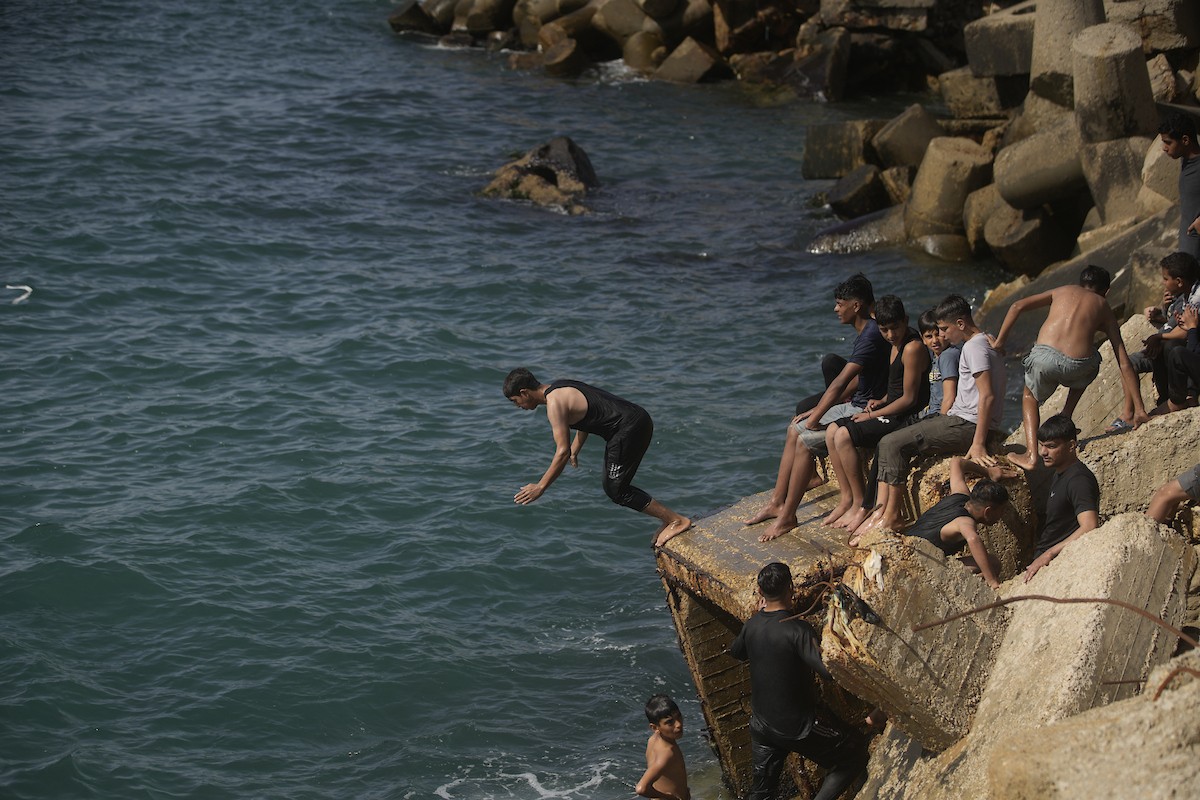 يسبح أطفال قرب ميناء غزة المدمر، في مشهد يعكس تمسكهم بلحظات الفرح رغم الدمار المحيط بهم. يُعدّ البحر في غزة المتنفس الوحيد لسكانها الذين يواجهون آثار الحرب والنزوح، والذين يعيشون في خيام تفتقر لأبسط مقومات الحياة، ١٢ فبراير ٢٠٢٦. تصوير: عمر أشتوي