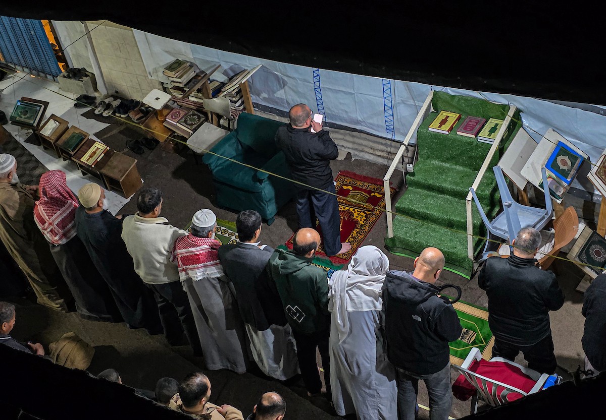 تجمّع المصلون في مسجد الفاروق المتضرر بشدة لأداء أول صلاة تراويح في شهر رمضان المبارك، رغم الدمار الذي خلفته الهجمات الإسرائيلية في خان يونس، جنوب قطاع غزة، في 17 فبراير/شباط 2026. صورة: تامر إبراهيم