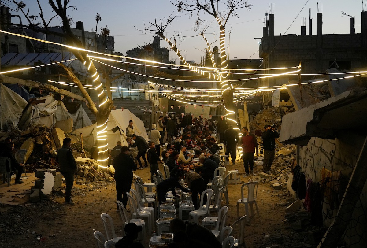 يتجمع الفلسطينيون بين المنازل المدمرة لتناول وجبة الإفطار معًا خلال شهر رمضان المبارك في شمال قطاع غزة، 22 فبراير/شباط 2026. صورة: عمر أشتوي