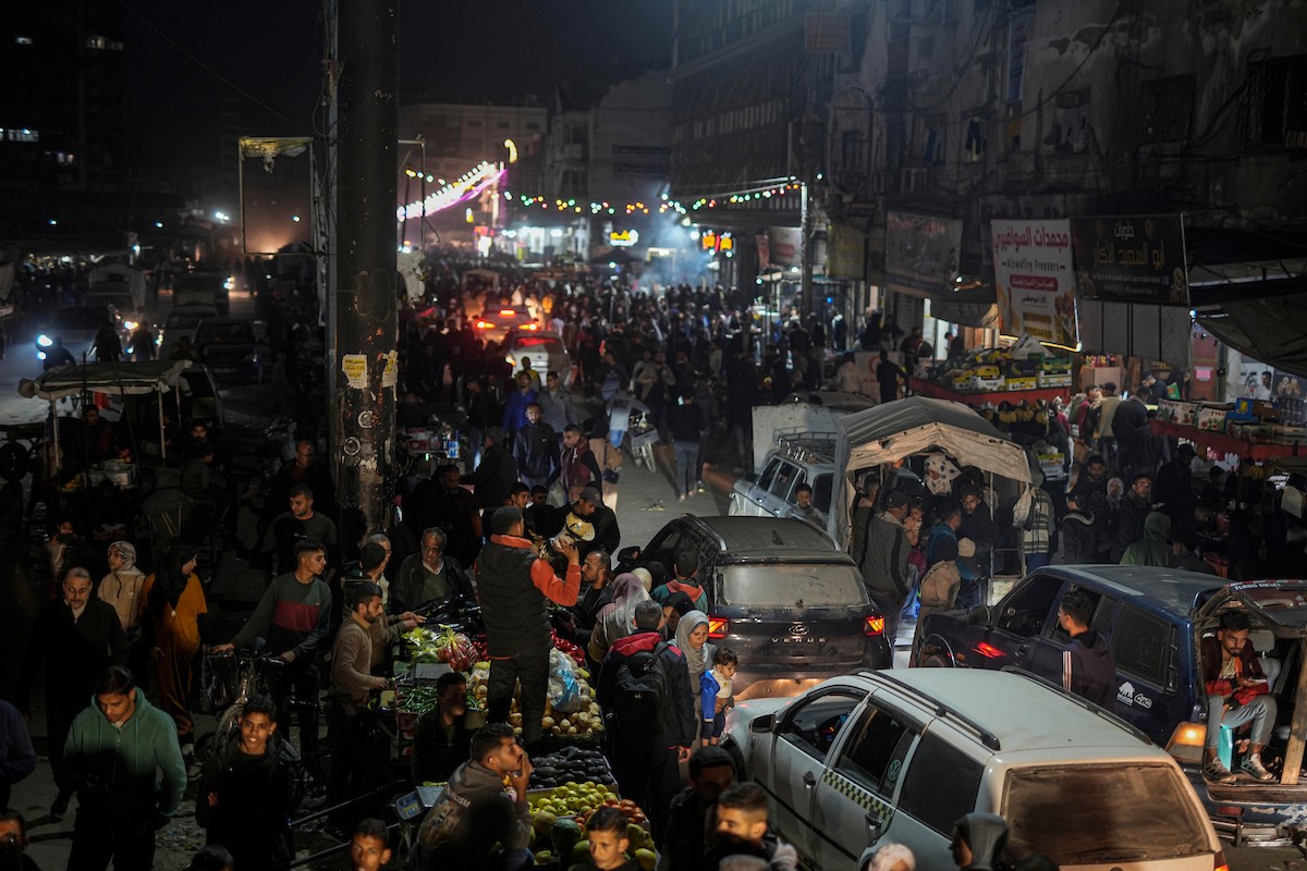 يتسوق الفلسطينيون في أول ليلة من شهر رمضان المبارك في سوق الزاوية، الواقع في قلب مدينة غزة والذي تضرر بشدة جراء الحرب الإسرائيلية. يعرض الباعة بضائعهم على أكشاك مزينة بالفوانيس والأضواء وأطعمة رمضان. مدينة غزة، 17 فبراير/شباط 2026. تصوير: عمر أشتوي