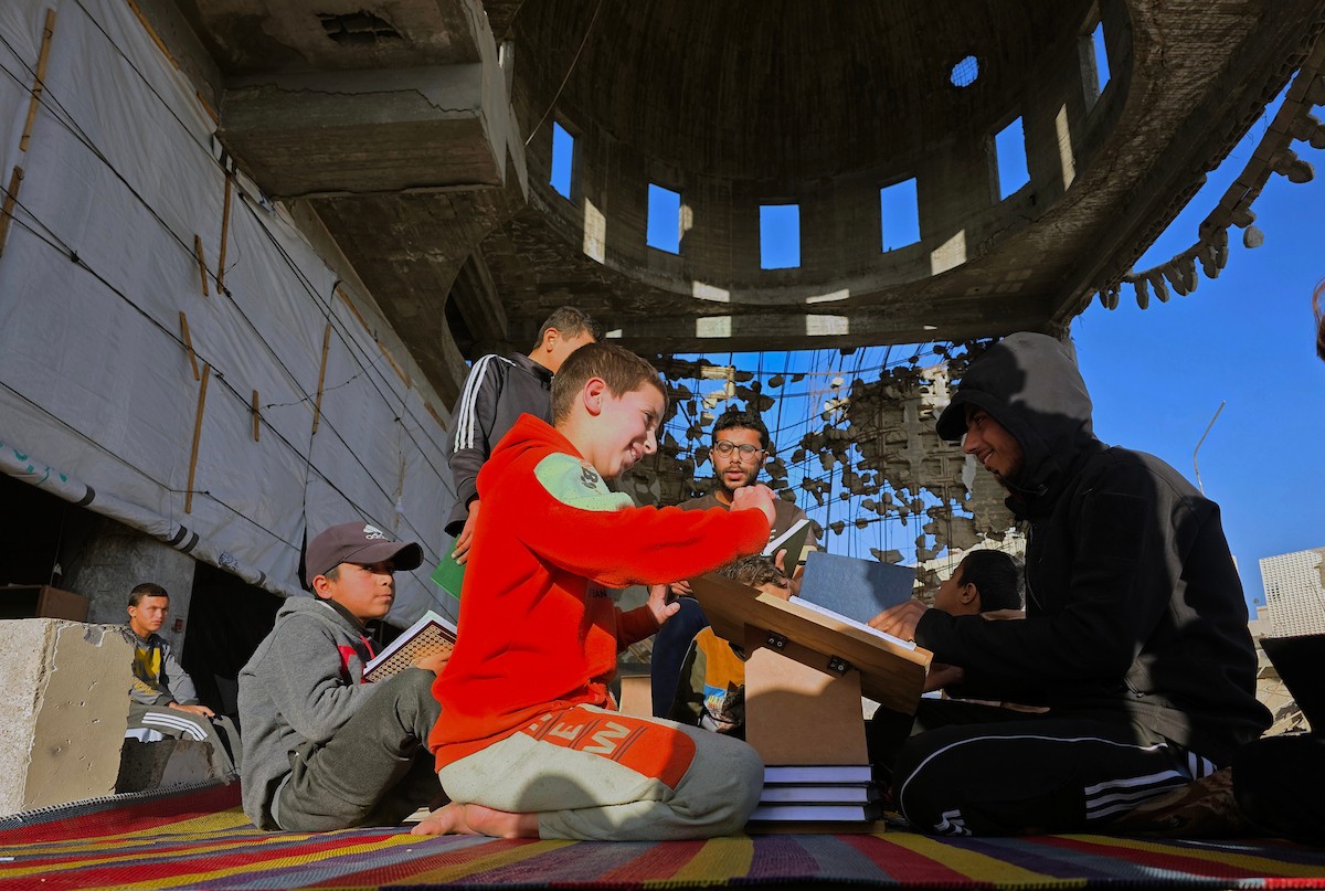 فلسطينيون، بينهم أطفال، يتلون ويحفظون القرآن الكريم خلال شهر رمضان داخل مسجد الألباني، الذي تضرر بشدة جراء الهجمات الإسرائيلية، في خان يونس، جنوب قطاع غزة، في 23 فبراير/شباط 2026. صورة: طارق محمد