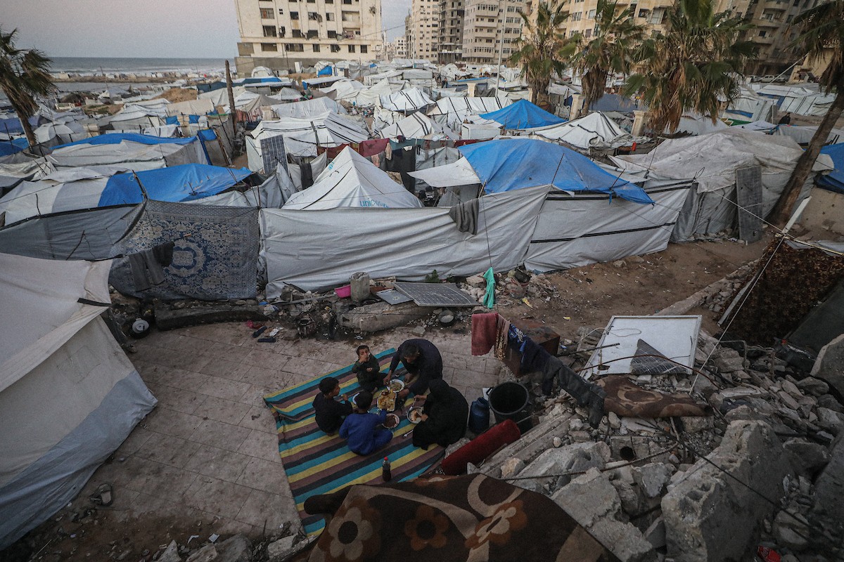 عائلة فلسطينية نازحة من بيت حانون تفطر في ثاني أيام رمضان في خيمة متداعية وسط أنقاض مسجد الحساينة على شاطئ مدينة غزة.19 فبراير/شباط 2026. تصوير: عمر أشتوي