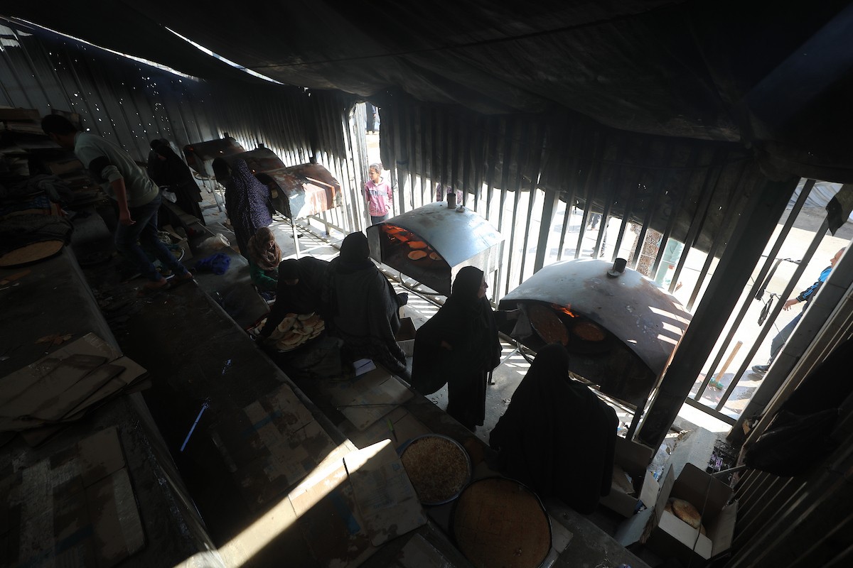 مجموعة من النساء يعملن داخل مخبز أُنشئ في مخيم اليرموك للاجئين بمدينة غزة، ضمن مبادرة إنسانية بالشراكة مع اللجنة الدولية للصليب الأحمر. تهدف المبادرة إلى تخفيف الأعباء المعيشية عن النساء النازحات، لا سيما خلال شهر رمضان. مدينة غزة، 25 فبراير/شباط 2026. تصوير: عمر أشتوي