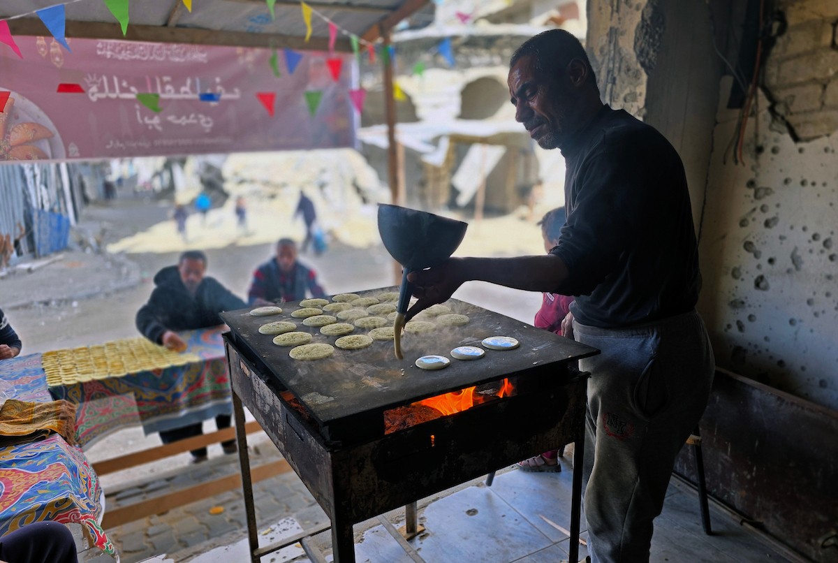 سليم البيوك ُيعدّ معجنات القطايف التقليدية باستخدام أساليب بدائية تعتمد على الحطب والنارمُواصلاً إحياء تقاليد شهر رمضان منذ أكثر من 20 عاماً، في سوق كراج رفح في خان يونس، جنوب قطاع غزة، في 12 فبراير/شباط 2026.تصوير: طارق محمد