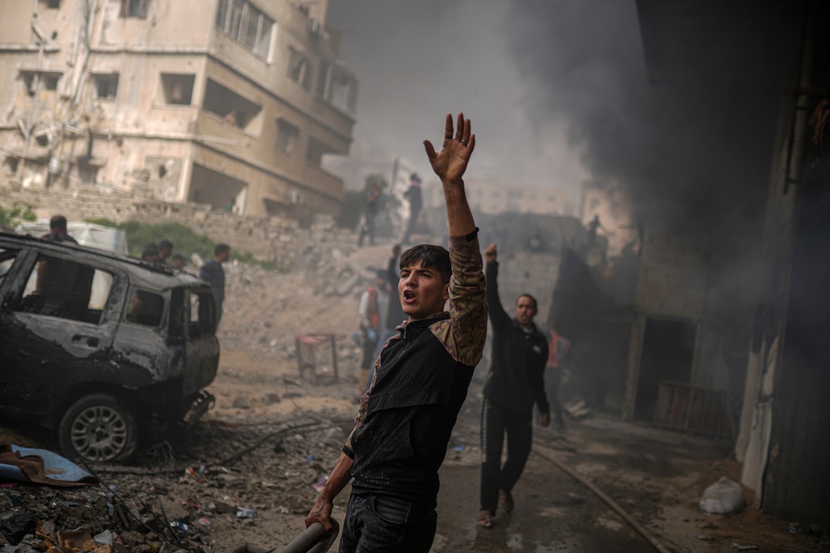 طواقم الدفاع المدني ومتطوعون من المواطنين أثناء محاولة إخماد حريق اندلع في مستودع تابع لمنظمة إغاثة في حي الرمال، غرب مدينة غزة، في 13 فبراير/شباط 2026. صورة: عمر أشتوي