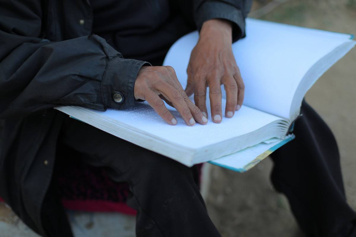 عائلة فلسطينية كفيفة تتناول وجبة الإفطار خارج خيمتها في مخيم بوسط قطاع غزة خلال شهر رمضان